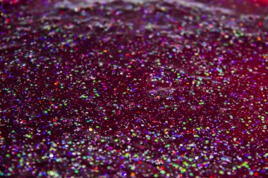 Kırmızı sıvıda bir parıltı. Renkli parıltılarla donatılmış çok güzel bir arka plan..