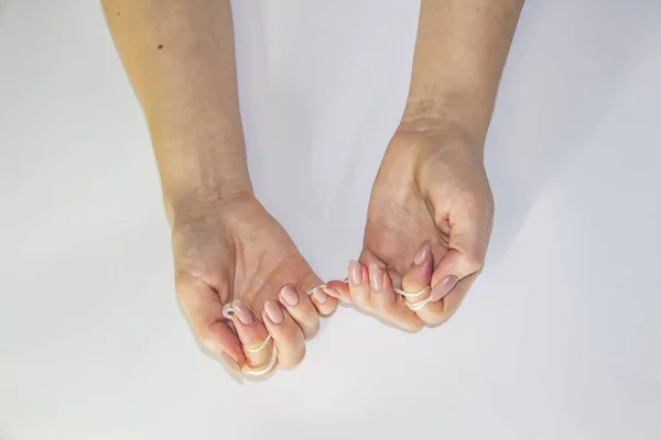 Women's hands hold the rope in the light background. Female hands pull the rope between each other. Hands pull the rope.