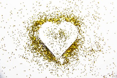 Kalp ve altın parıltılı bir kompozisyon. Altın parıltılarının arka planı ve dokusu. Şatafatlı altın parıltısı. Parlak bir dokusu ve kalbi var.