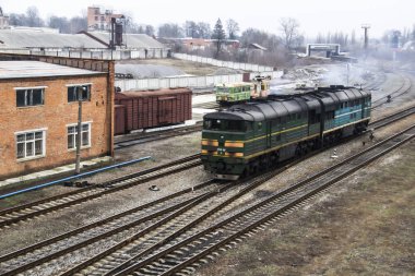Ukrayna treni şehre geliyor. Tren yolculuklarının demiryollarında. Eski yeşil lokomotifler rayların üzerinde