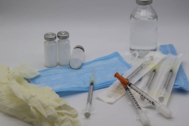 Diyabet ve şırınga için insülin şişeleri. Şırıngalarla arka plandaki sağlık sigortası kavramı. Masanın üzerinde tıbbi eşyalar ve şırıngalar var..