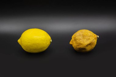 Koyu arka planda bozulmuş ve kuru limonlu taze limon. Arka planda kurumuş ve taze limon var. Öncesinde ve sonrasında kavram