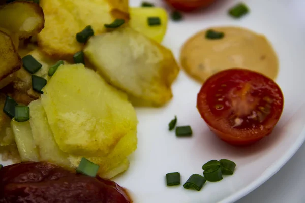 土制土豆 新鲜黄瓜 樱桃西红柿和酱汁放在白盘上 带有蔬菜背景的美味的乌克兰油炸土豆 午饭做了好吃的饭 — 图库照片