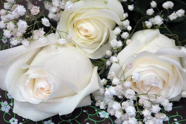 A bouquet of three white roses decorated with flowers — Stock Photo, Image