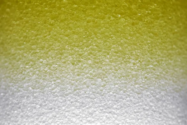 Yellow bubbles of micellar water macro as background — Stock Photo, Image