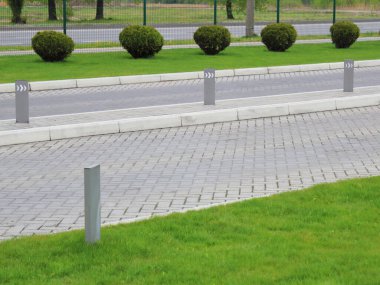 Şehirdeki yeşil çimenli düzgün bir park girişi.