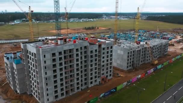 Беспилотный летательный аппарат вокруг строительного крана, процесс разработки многоэтажных многоквартирных домов — стоковое видео