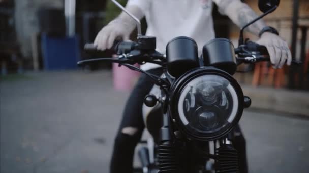 가죽 장갑과 검은 후드에 자전거 타는 오토바이를 시작합니다. — 비디오