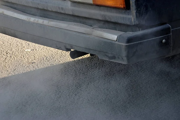 smoke from the exhaust pipe of an old dirty car