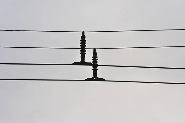 trolley wires with dielectric insulators on the background of the autumn sky