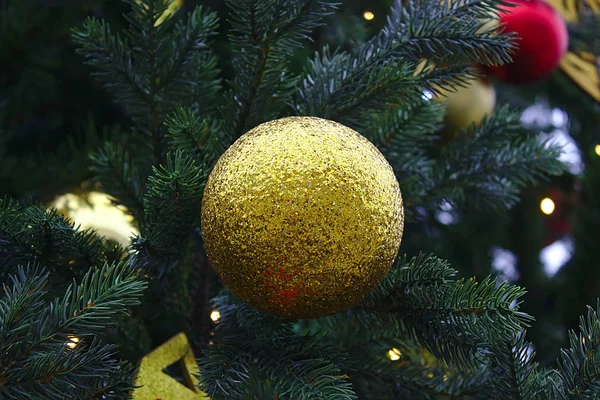 Christmas tree toy: ball with gold sequins on the branch