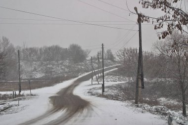 Karlı bir günde tepeye çıkan kırsal yol