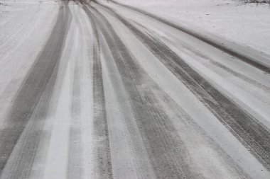 Yoldaki araba izleri taze karla kaplı.