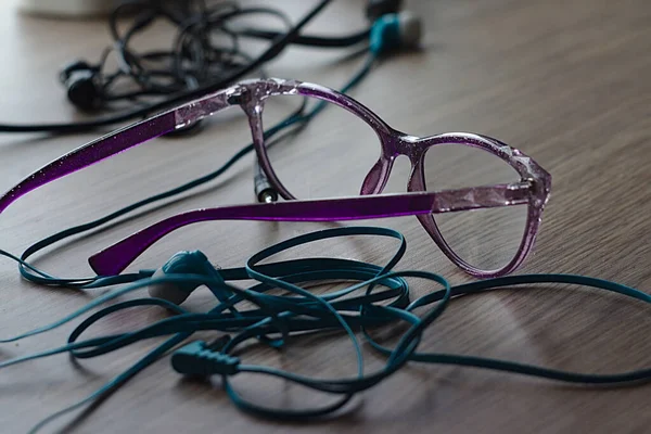 Glasögon Och Hörlurar Med Trasslig Kabel Bordet — Stockfoto
