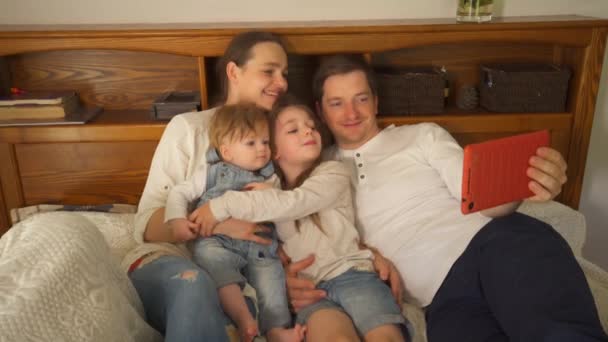 Батько, мати, їх милі сини і дочка позують для планшета селфі. кишеньковий — стокове відео