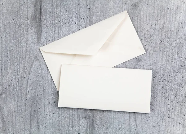 Envelope e cartão sobre fundo de madeira — Fotografia de Stock