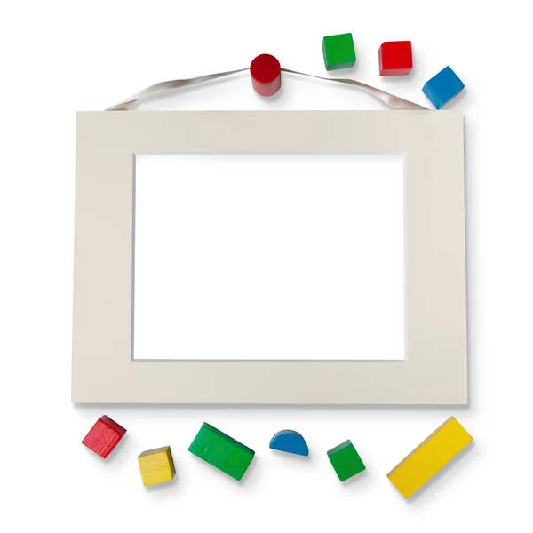 Empty frame with ribbon and wooden toys — Stock Photo, Image