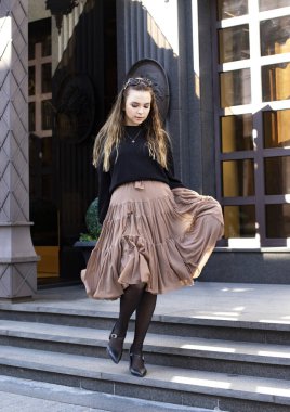 Güzel elbiseli güzel kız mankeni merdivenlerden aşağı iniyor.