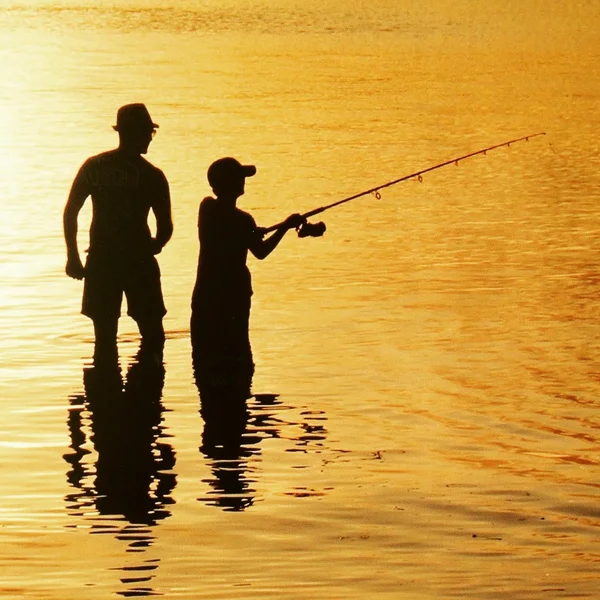 Silhueta de pai e filho pesca ao pôr do sol, conceito de dia dos pais — Fotografia de Stock