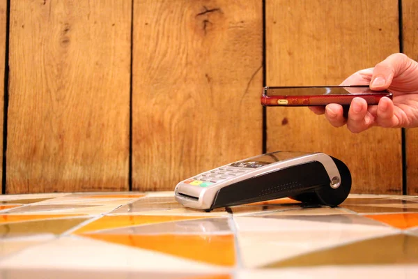 Безконтактний платіжний телефон pdq з рукою, що тримає кредитну картку для оплати — стокове фото