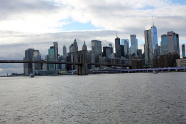 New York, ABD - 20 / 12 / 2019: New York 'taki Brooklyn köprüsü, Hudson Nehri' nin karşısındaki Manhattan gökdelenleri.