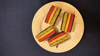 Gökkuşağı pastası dilimleri ve tabakta kırıntılar