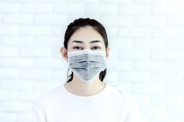 Asian girl wearing a black mask.Nose mask protects against dust on the face of  women.Do not focus on the main object of this image.