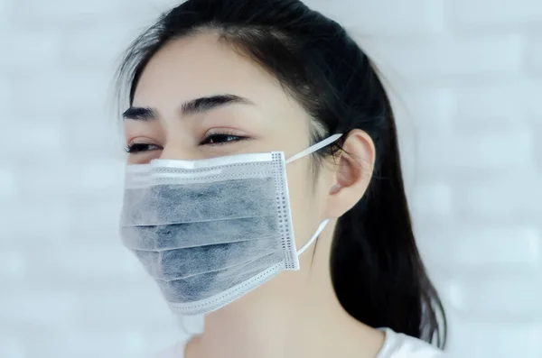 戴黑色面罩的亚洲女孩 鼻罩能防止妇女脸上的灰尘 背景用模糊的图像 图库图片
