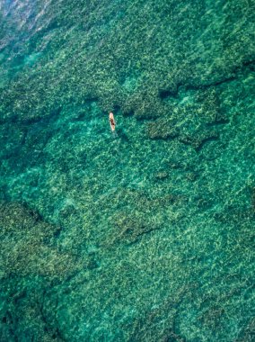 Hawaii 'deki mercan resifinin üzerinde bir sörfçünün tepeden aşağı görüntüsü.