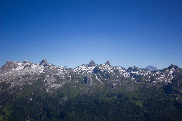 Zwitserse bergen bedekt met sneeuw op een zonnige dy — Stockfoto