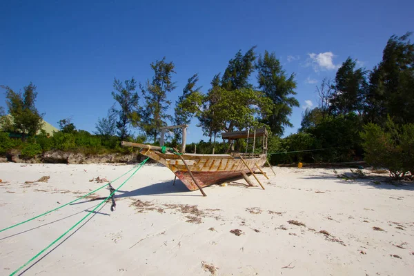 stranded boat on a white sand beach in Africa