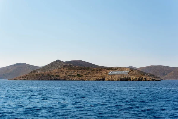 Côte rocheuse avec un grand drapeau grec dans l'île de Kalymnos, Dodécanèse, Grèce — Photo
