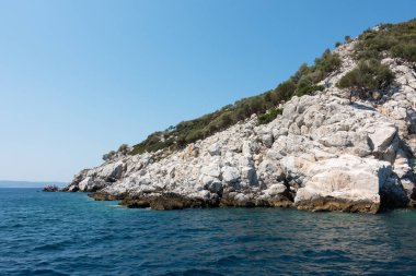 Kelyfos adası, Marmaras, Chalkidiki, Yunanistan 'daki Rocky sahili ve muhteşem sular