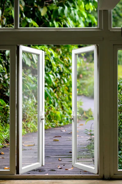 自然への白いオープンガラスの扉歩く ロイヤリティフリーのストック写真