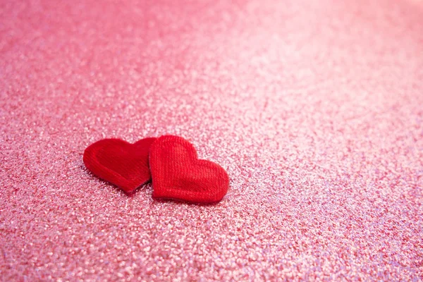 Dos pequeños corazones rojos hechos a mano sobre fondo bokeh rosa brillante. Feliz día de San Valentín. Espacio para el texto. Enfoque selectivo . — Foto de Stock