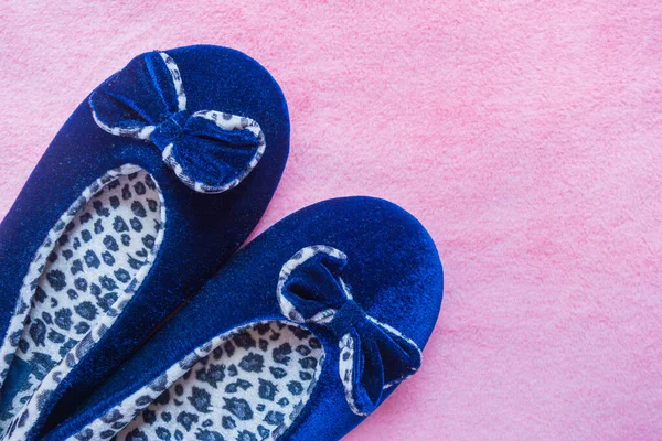 Blue leopard slippers on a fluffy pink carpet. Home women's or children's clothing. The concept of home warmth and comfort. Selective focus. Space for text