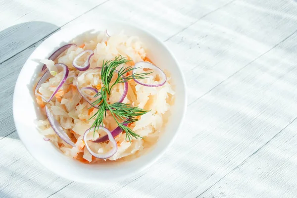 Traditionel surkål med dild og løg i en hvid kop. Begrebet ordentlig ernæring. Naturligt probiotisk. Selektivt fokus, kopieringsplads til tekst . - Stock-foto