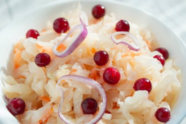 Beyaz bardakta yaban mersini ve soğanlı lahana turşusu, yakın plan. Probiyotik gıda konsepti. Seçici odak, metin için alanı kopyala