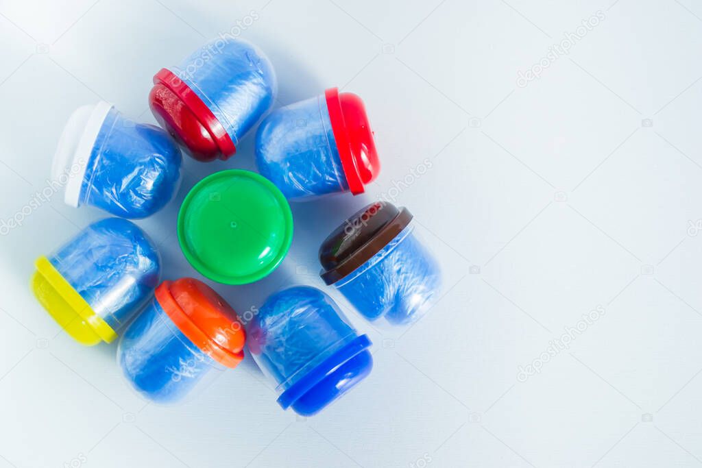 Blue shoe covers in individual capsules with multi-colored caps. Disposable shoe covers. Protection concept. Space for text