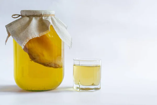 Kombucha Healthy natural probiotic drink in a glass jar and a glass. Proper nutrition. On a white background with space for text.