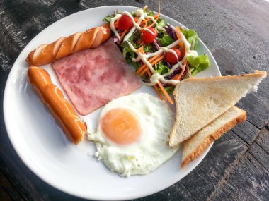 Kahvaltı gıdalar - kızarmış yumurta, pastırma, sosis ekmek ve vegetabl