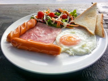 Kahvaltı gıdalar - kızarmış yumurta, pastırma, sosis ekmek ve vegetabl