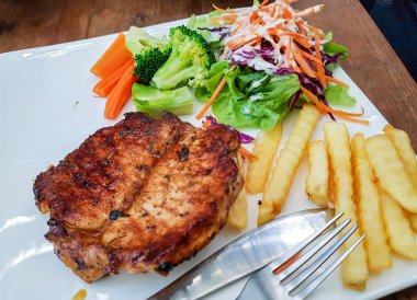 Kızarmış domuz biftek sebze salatası ve patates ile