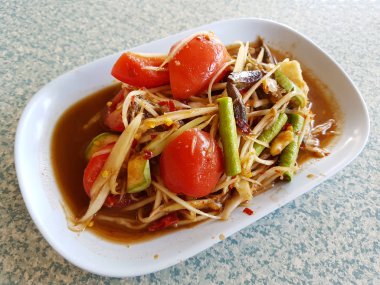 Papaya salatası (Somtum) beyaz tabakta, Tayland'ın ünlü gıda.