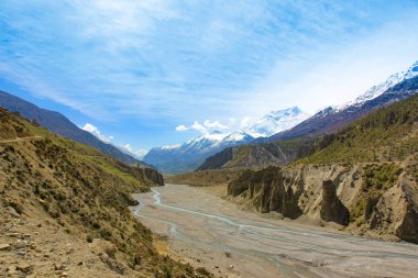 Nepal dağlarında bir nehir. Uzak kar zirveleri ve mavi gökyüzü