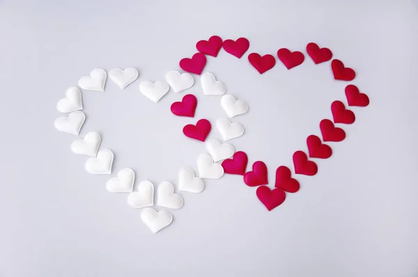 Zwei Herzen weiß und rot auf weißem Hintergrund. Valentinstag. — Stockfoto