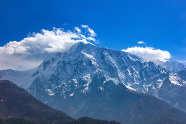 Bulutlu mavi gökyüzüne karşı Nepal karlı dağları