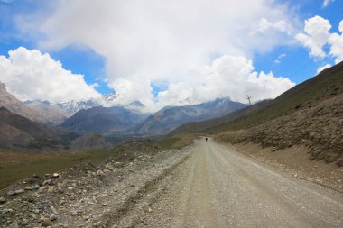 Mavi gökyüzünün arka planında Nepal dağlarında toprak yol 