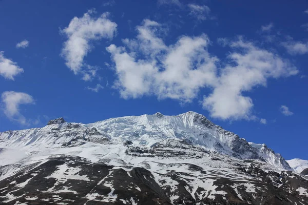 Montanhas nevadas contra o céu azul com nuvens brancas. Montanha — Fotografia de Stock