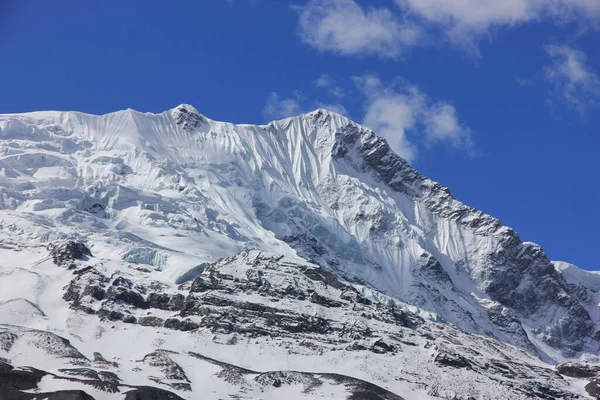 Schneebedeckte Berge gegen den blauen Himmel mit weißen Wolken. Berg — Stockfoto